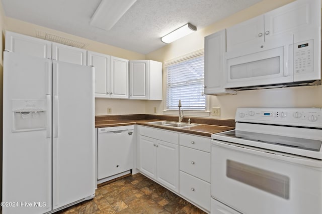 kitchen featuring a textured ceiling, white cabinetry, sink, and white appliances