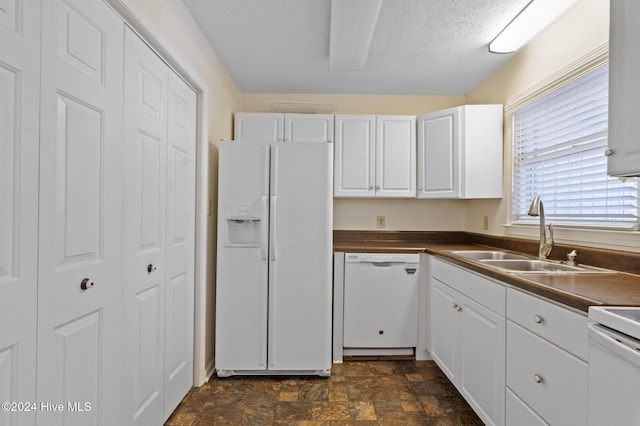 kitchen with a textured ceiling, white cabinetry, white appliances, and sink