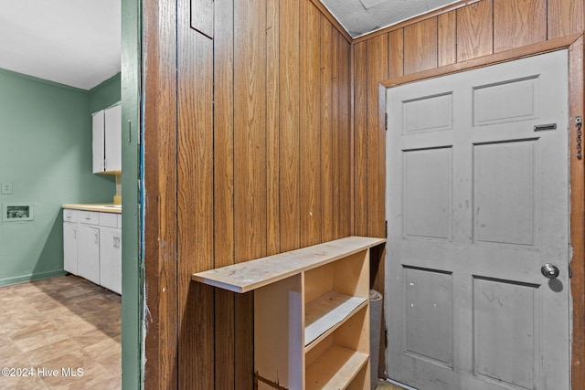 interior space featuring white cabinets and wooden walls