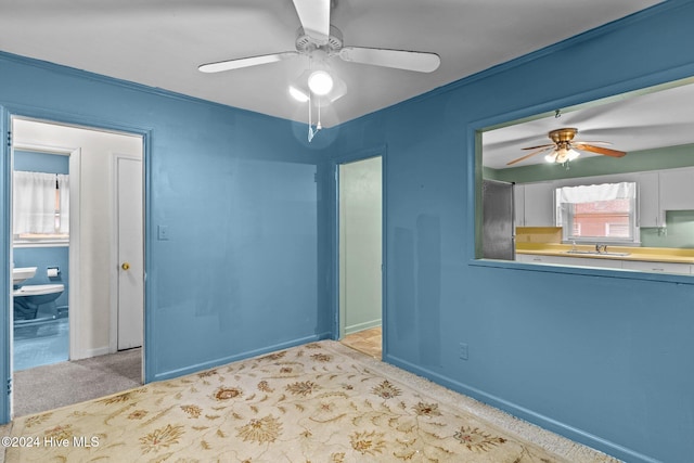 empty room featuring ceiling fan, sink, and light carpet