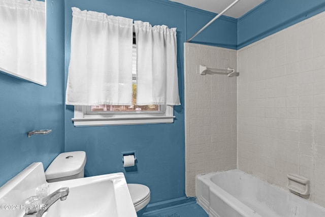 bathroom with tiled shower / bath combo and toilet