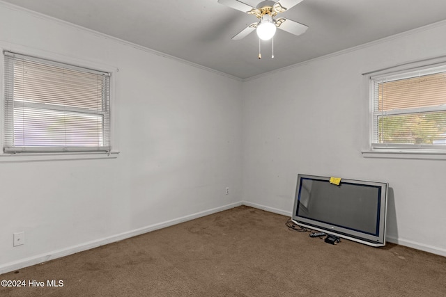 carpeted empty room featuring ceiling fan and crown molding