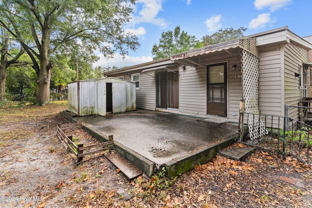 rear view of property with a storage unit