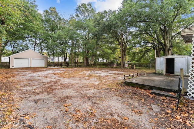 view of yard with a garage and an outbuilding