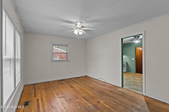 spare room featuring ceiling fan, wood-type flooring, and ornamental molding