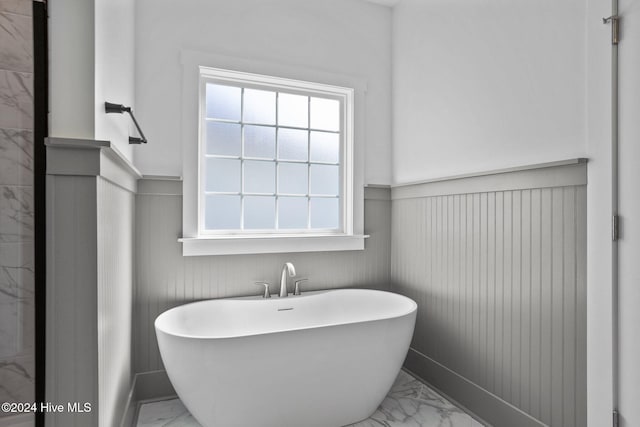 bathroom featuring plenty of natural light and a tub