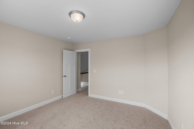 spare room featuring light carpet