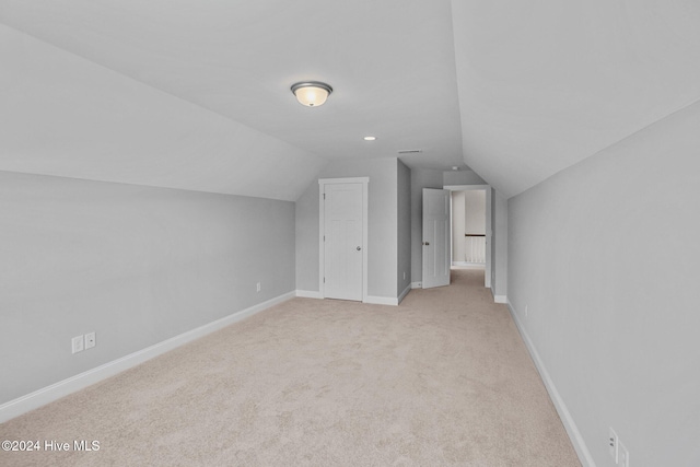 bonus room with light carpet and lofted ceiling