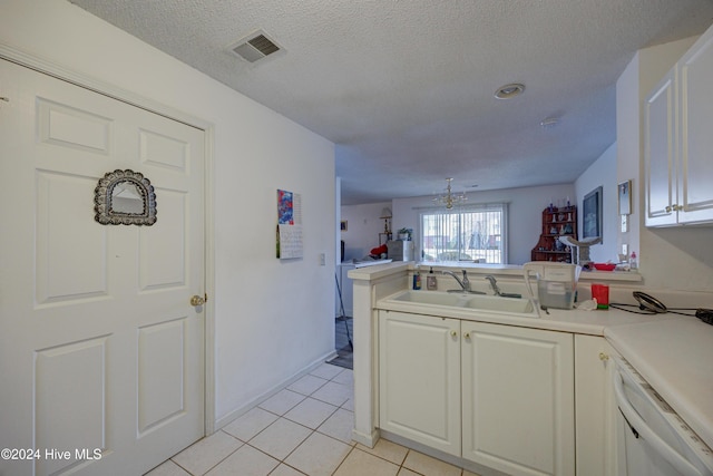 kitchen featuring dishwasher, sink, white cabinets, light tile patterned floors, and a textured ceiling