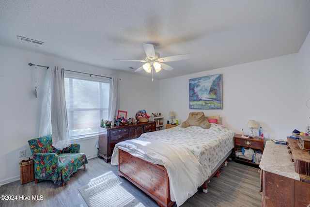 bedroom featuring wood-type flooring, ceiling fan, and a textured ceiling