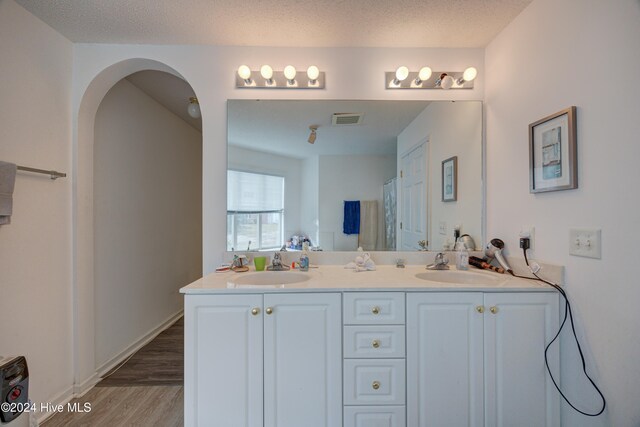 bathroom with vanity, hardwood / wood-style floors, and a textured ceiling