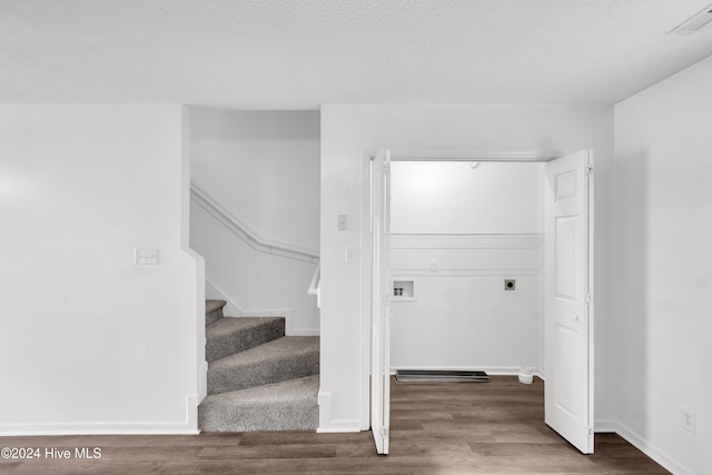 stairway featuring a textured ceiling and hardwood / wood-style flooring