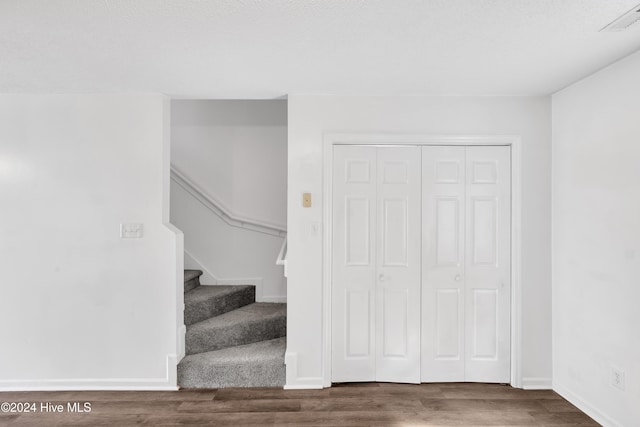 staircase featuring hardwood / wood-style flooring and a textured ceiling