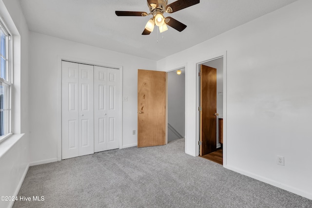 unfurnished bedroom with carpet floors, a closet, and ceiling fan