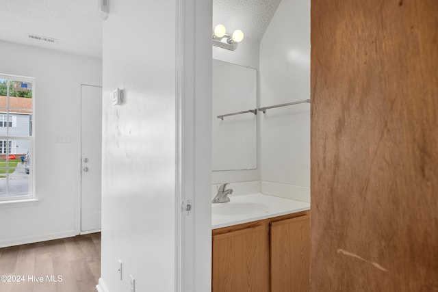 bathroom featuring vanity, a textured ceiling, and hardwood / wood-style flooring