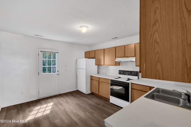 kitchen featuring a textured ceiling, sink, white appliances, and hardwood / wood-style flooring