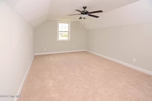 additional living space featuring ceiling fan, light colored carpet, and vaulted ceiling