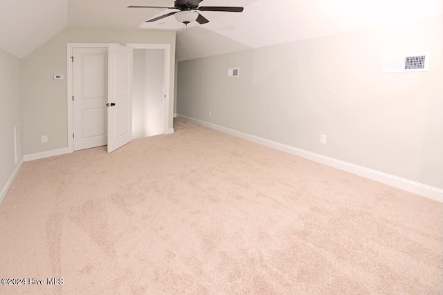 additional living space featuring ceiling fan, light colored carpet, and vaulted ceiling