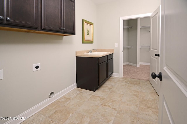 laundry area featuring cabinets, sink, and hookup for an electric dryer