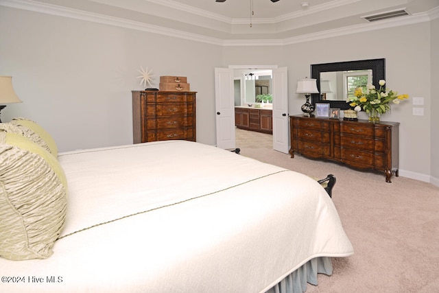 carpeted bedroom featuring ensuite bath, ceiling fan, crown molding, and a raised ceiling