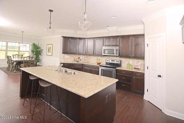 kitchen featuring sink, hanging light fixtures, appliances with stainless steel finishes, and dark brown cabinets