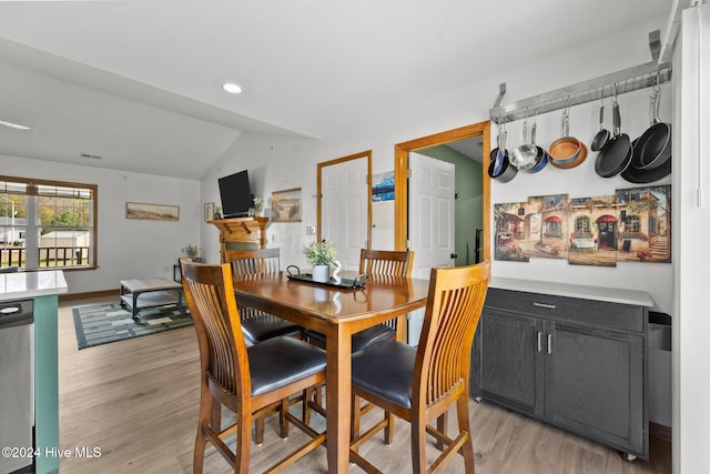 dining room with light hardwood / wood-style floors and lofted ceiling