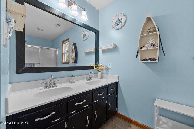 bathroom featuring hardwood / wood-style floors, vanity, and walk in shower