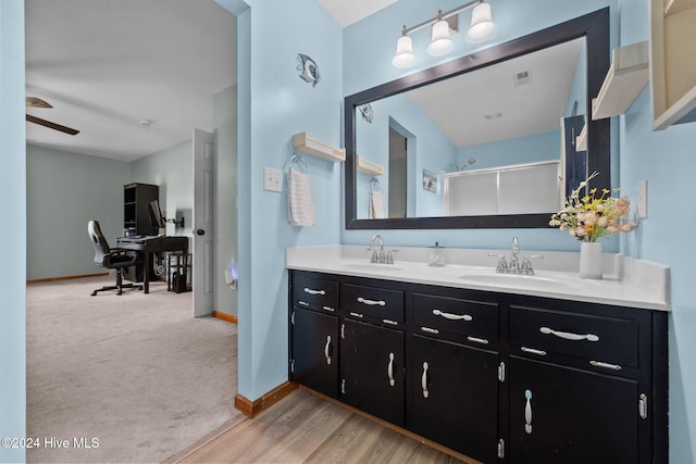 bathroom featuring ceiling fan, wood-type flooring, a shower with door, and vanity