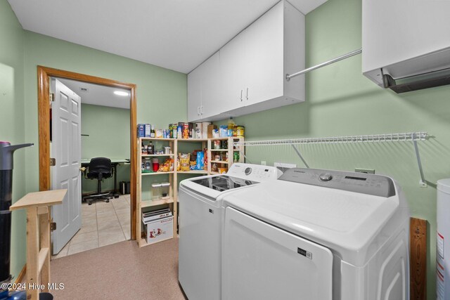 washroom with washer and clothes dryer, cabinets, and light tile patterned floors