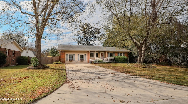 single story home with covered porch and a front lawn