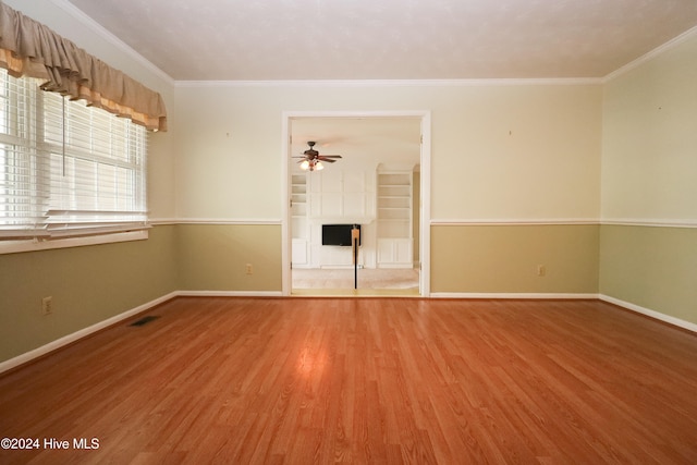 unfurnished room with hardwood / wood-style flooring, ceiling fan, and crown molding