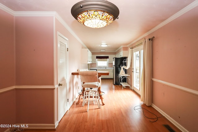 corridor featuring sink, light hardwood / wood-style floors, and ornamental molding