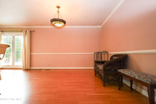 living area with hardwood / wood-style floors and ornamental molding