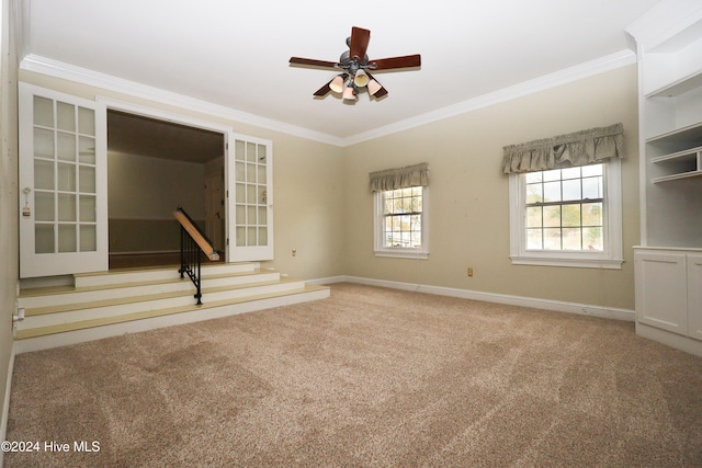 carpeted spare room with ceiling fan, french doors, and ornamental molding