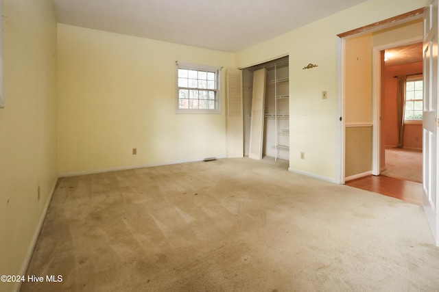 unfurnished bedroom with light carpet and multiple windows