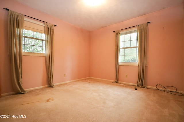 empty room with plenty of natural light and light colored carpet