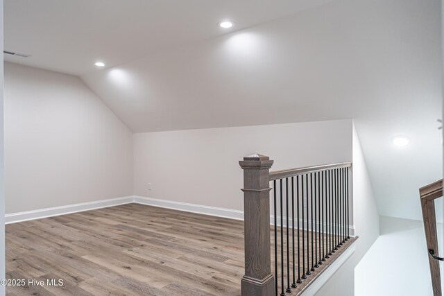 bonus room featuring vaulted ceiling, wood finished floors, and visible vents