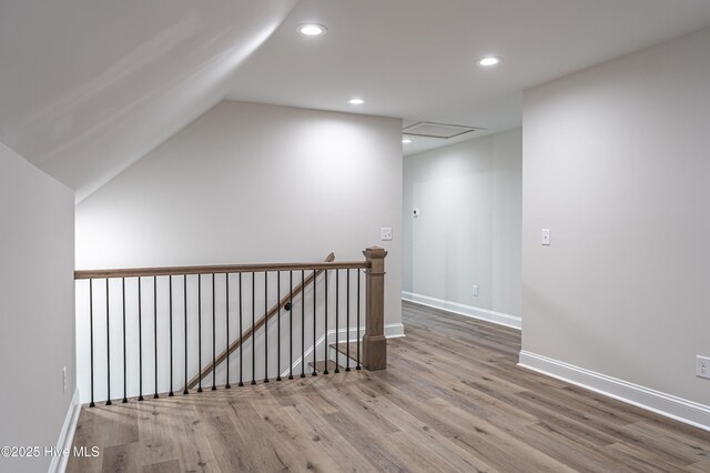 additional living space with vaulted ceiling, wood finished floors, a ceiling fan, and baseboards