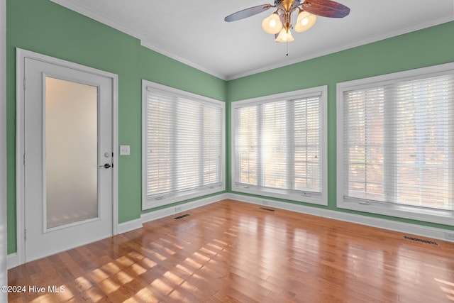 interior space featuring wood-type flooring, ceiling fan, and crown molding