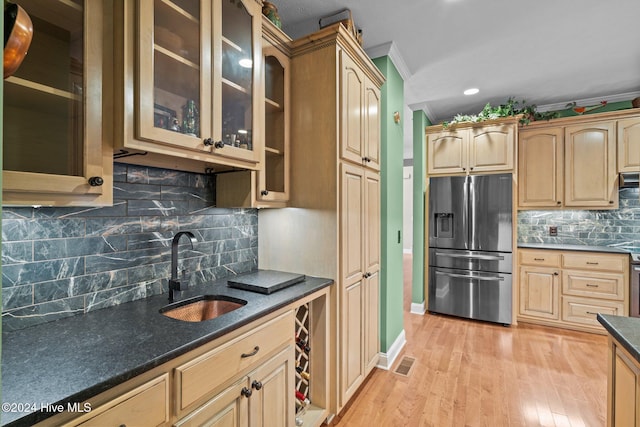 kitchen with sink, stainless steel fridge with ice dispenser, backsplash, crown molding, and light hardwood / wood-style floors