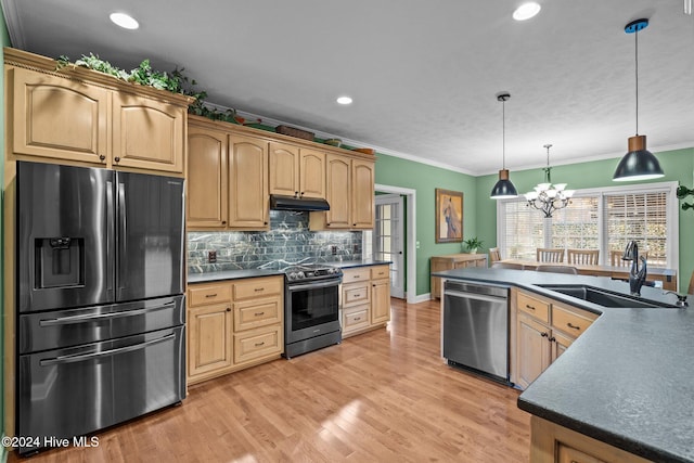 kitchen featuring appliances with stainless steel finishes, crown molding, sink, decorative light fixtures, and an inviting chandelier