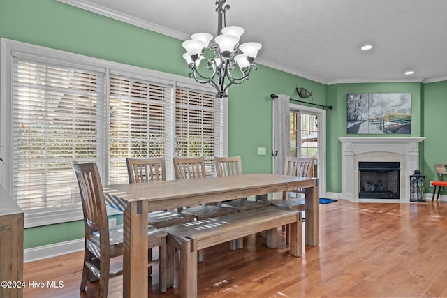 dining area featuring plenty of natural light, crown molding, and an inviting chandelier