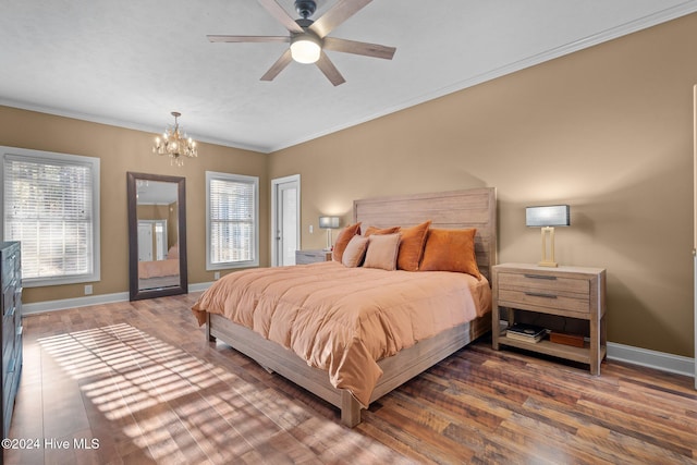 bedroom with ceiling fan with notable chandelier, ornamental molding, and dark wood-type flooring