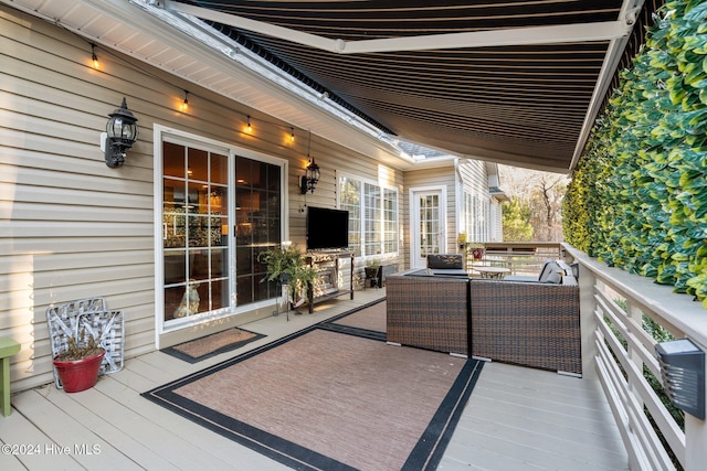 wooden terrace with an outdoor living space