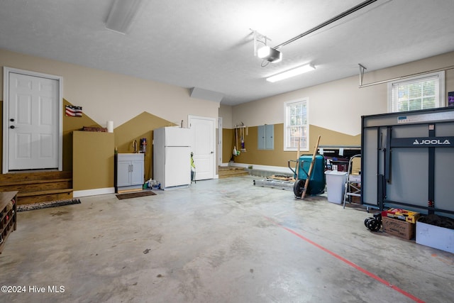 garage with white fridge and a garage door opener