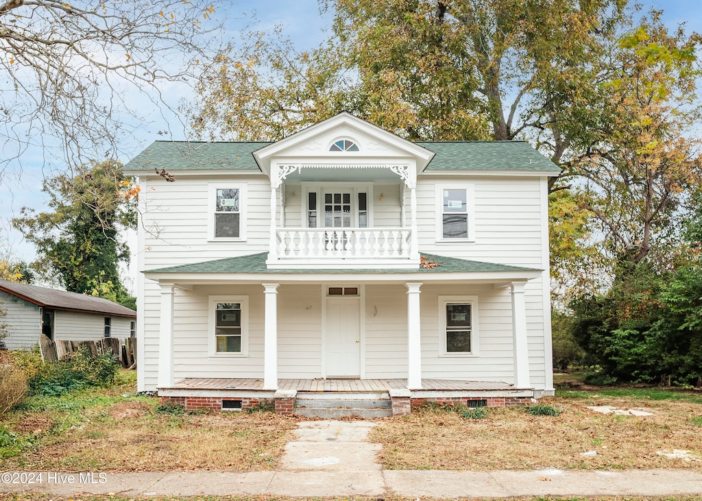 greek revival inspired property featuring a porch and a balcony