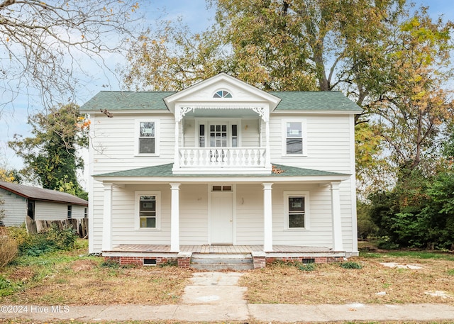 greek revival inspired property featuring a porch and a balcony