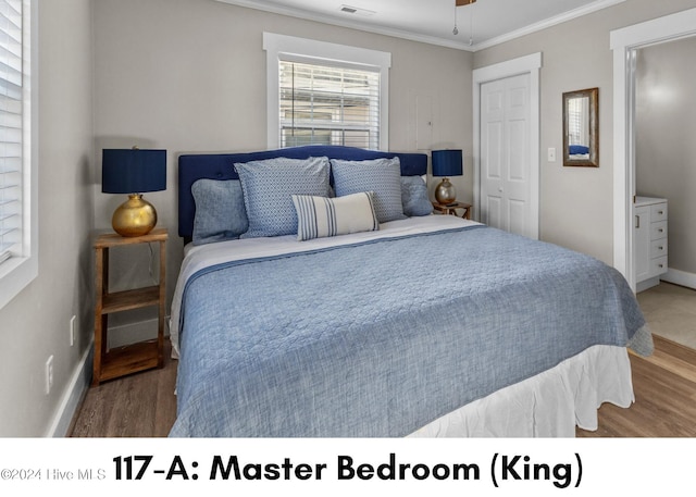 bedroom featuring wood-type flooring, a closet, crown molding, and ceiling fan