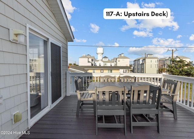 wooden deck with outdoor dining area and a residential view