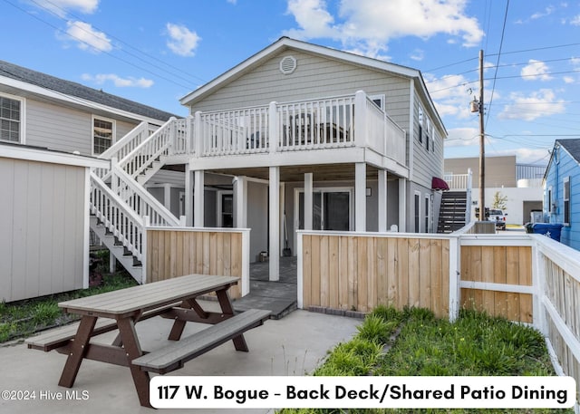 rear view of property featuring fence, a patio, a wooden deck, and stairs